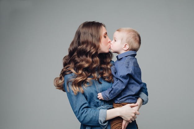 Laughing son and smiling mother in studio