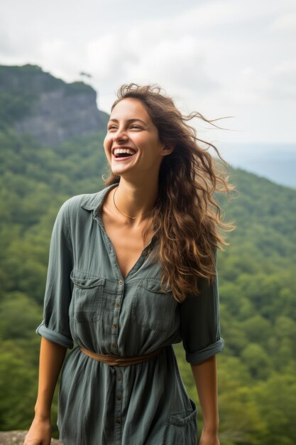 Laughing woman in green dress standing on mountaintop