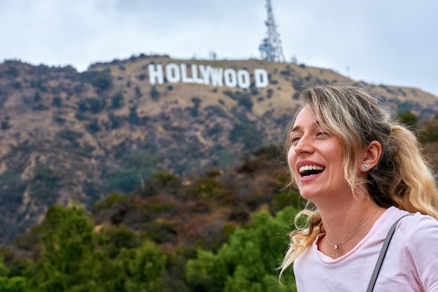 Laughing woman and Hollywood sign Los Angeles, USA