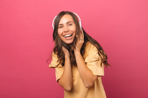 Laughing woman is having fun and listening to the music through headphones