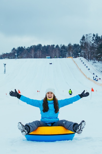 Photo laughing woman on snowing tube. winter leisure activity