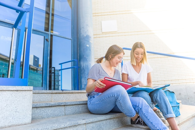 Laughing women studying near university building