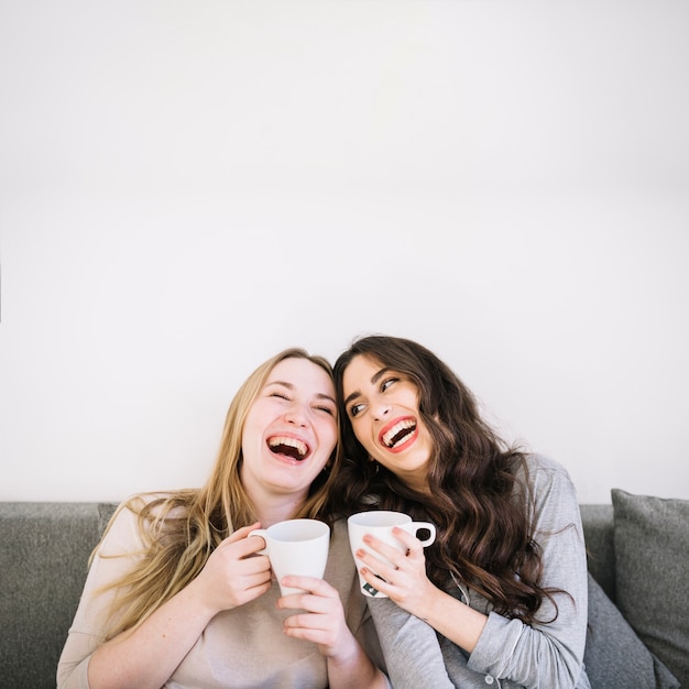 Laughing women with mugs