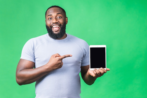 녹색 배경 위에 절연 터치 패드 태블릿 PC를 들고 젊은 아프리카계 미국인 흑인 남자를 웃 고.