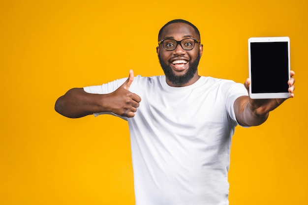 Laughing Young African American man Holding a Touch Pad Tablet PC on. Thumbs up.