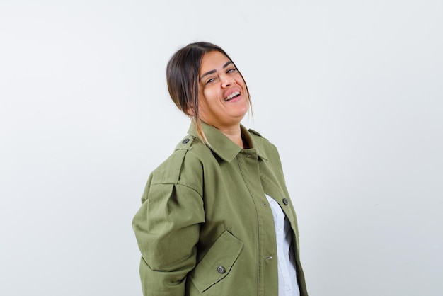 The laughing young woman is looking at camera on white background