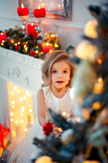 Laughinhg kind gluren van achter de kerstboom