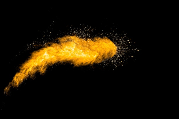 Launched orange color powder explosion on black background. 