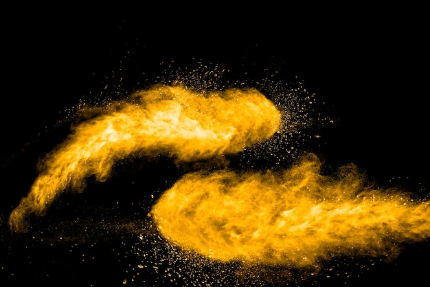 Launched orange color powder explosion on black background. 