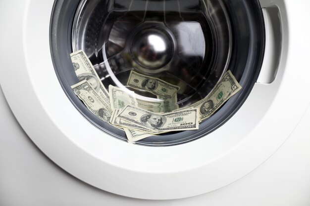 Laundering of dirty money in washing machine close up