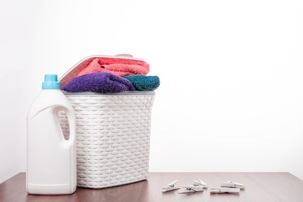 Laundry basket towels liquid detergent are on the table