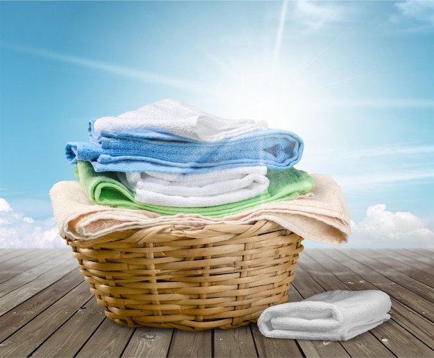 Photo laundry basket with colorful towels on background