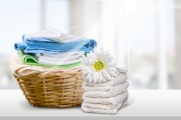 Laundry Basket with colorful towels on background