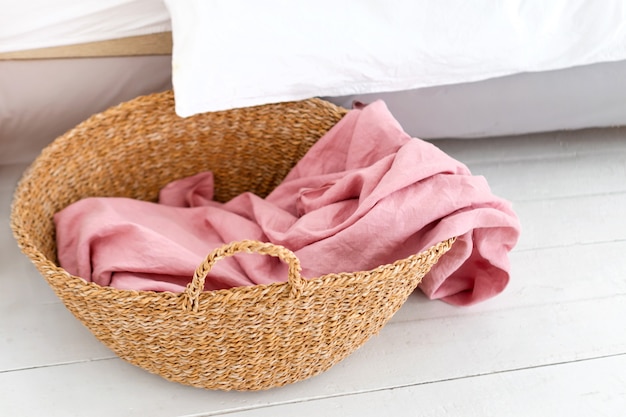 Photo laundry basket with pink towel. interior of white stylish room with laundry basket