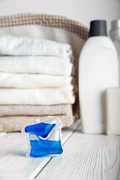 Laundry capsules. Laundry gel in capsules and towels close-up.