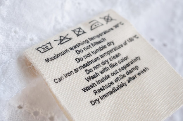 Photo laundry care washing instructions clothes label on fabric texture background