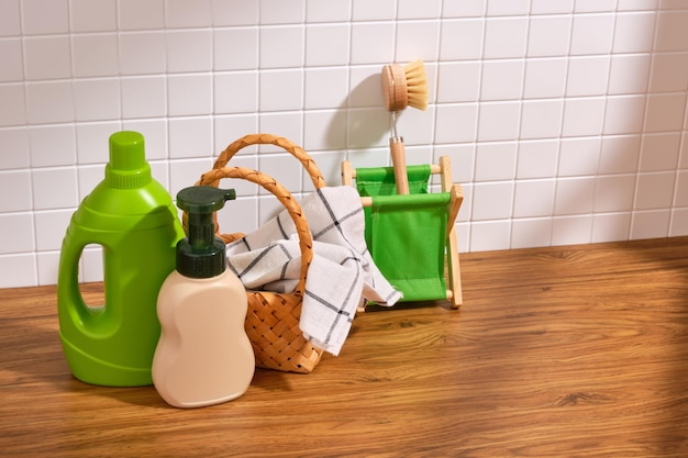 Photo laundry and household detergent bottles and a dirty towel in a basket ecological cleaning brush