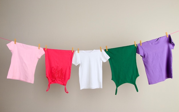 Laundry line with clothes on wall background