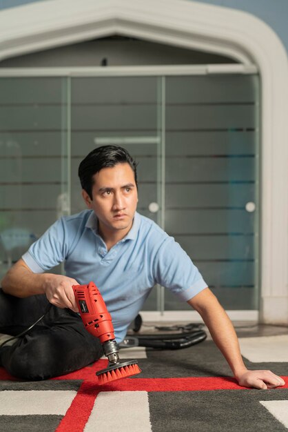 Laundry personnel cleaning carpet with electric brush