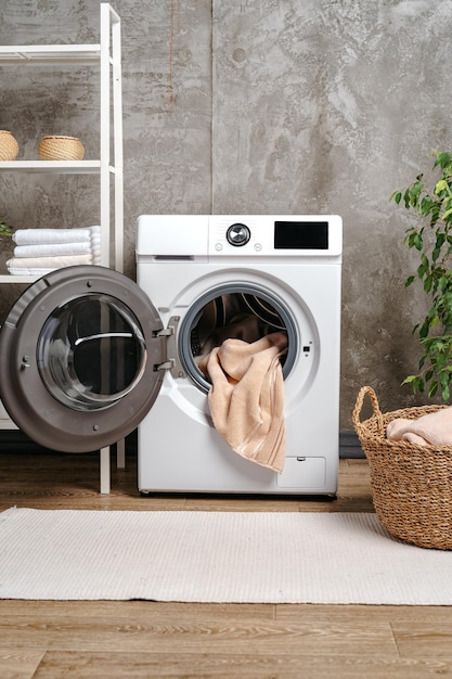 Laundry room interior with washing machine near gray grunge wall