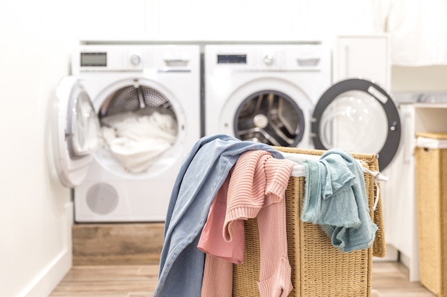 Laundry room with basket and washing and drying machines 