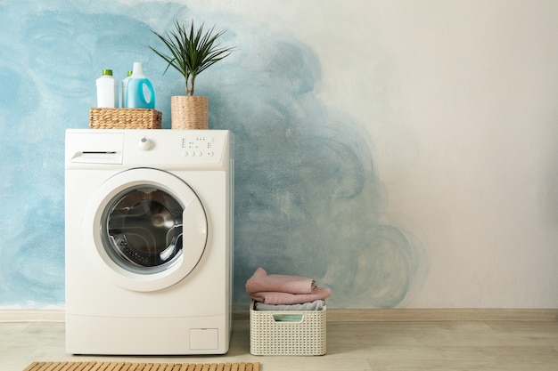 Photo laundry room with washing machine against blue wall, space for text