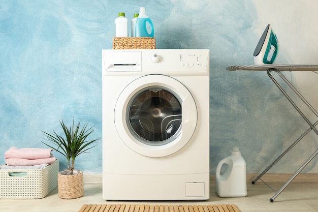 Laundry room with washing machine against blue wall