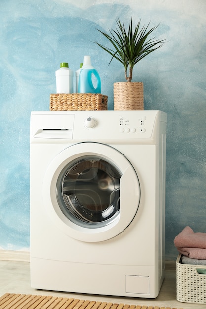 Laundry room with washing machine against blue wall