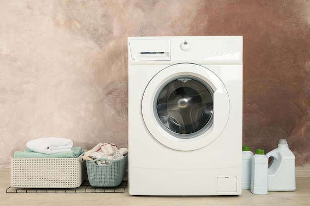 Laundry room with washing machine against brown wall