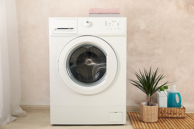 Photo laundry room with washing machine against light brown wall