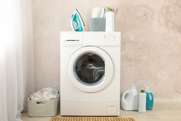 Photo laundry room with washing machine against light brown wall