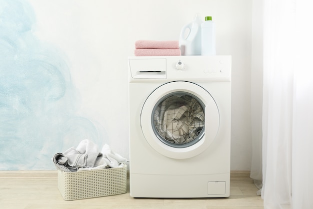 Laundry in a washing machine and in basket, space for text