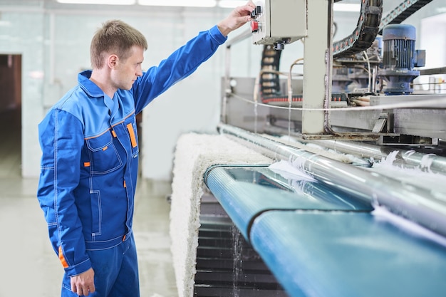 Lavanderia in procinto di lavorare su una macchina automatica per il lavaggio dei tappeti nel lavaggio a secco