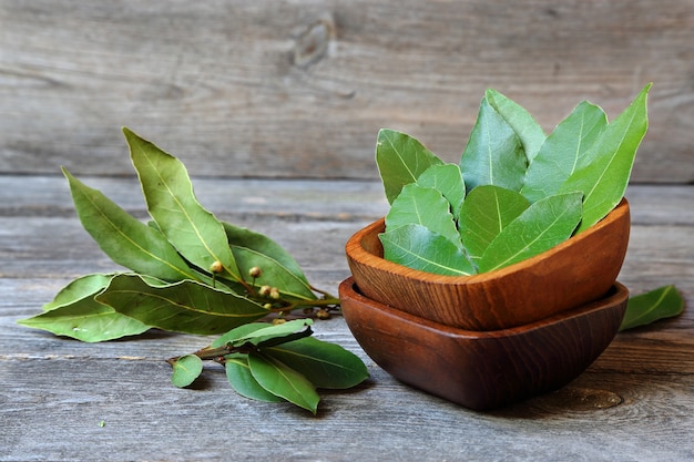 Laurel leaves in a wooden bowl on a gray kitchen table