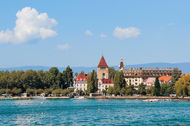 Lausanne, Switzerland - August 26, 2018: Chateau Ouchy and Lake Geneva quay in Lausanne, Switzerland. People on the background