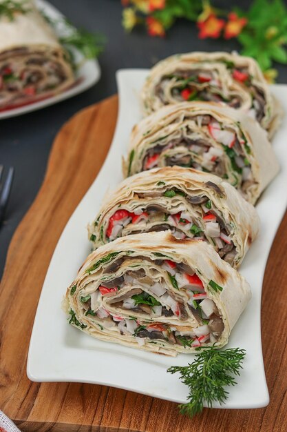 Lavash roll with champignons, crab sticks and cheese on dark background, festive appetizer