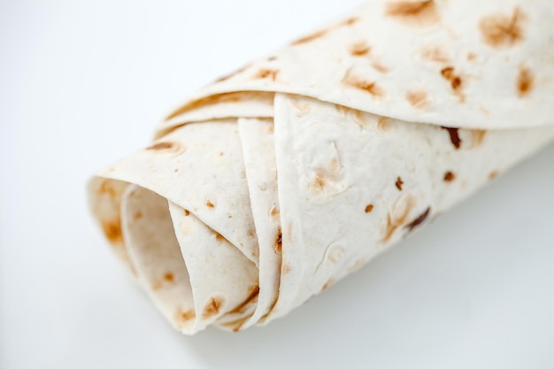 Lavash rolled into tube without filling top view selective focus