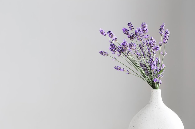 Lavendelbloemen in keramische vaas op grijze achtergrond