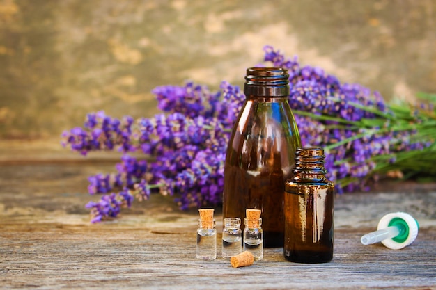 Lavendelolie in verschillende flessen op houten achtergrond.