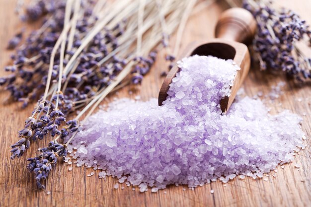 Lavender bath salt and dried flowers of lavender on wooden table