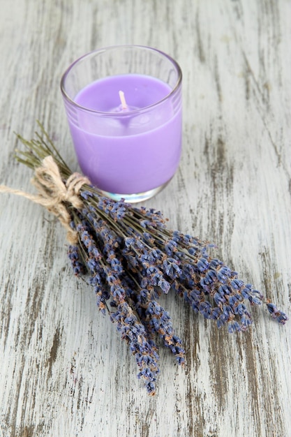 Lavender candle with fresh lavender on wooden background