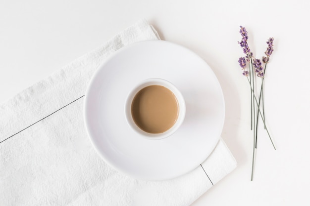 Photo lavender and cup of coffee on napkin over white backdrop