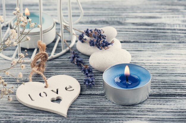 Lavender flowers, blue lit candle and heart