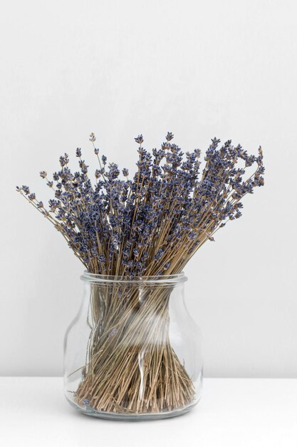Foto fiori di lavanda in vaso di vetro sfondo di legno bianco concetto di spa aromaterapia fiori di lavanda da vicino