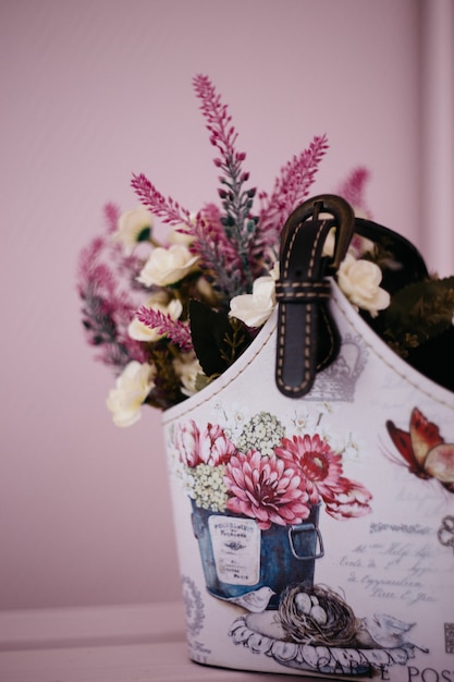 Photo lavender flowers in a homemade basket on a pink background, home decor