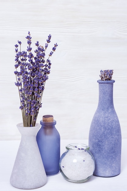 Lavender flowers and sea salt for for cosmetic procedures, wooden background, spa theme, copy space.