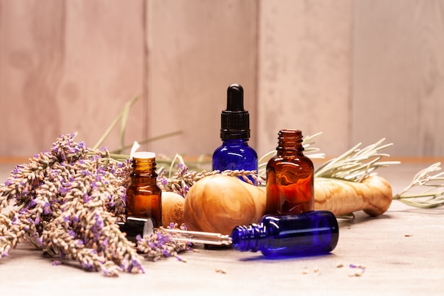 Lavender mortar and pestle and bottles of essential oils for aromatherapy