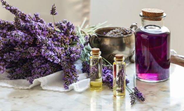 Lavender oil bottles,  natural herb cosmetic consept with lavender flowers flatlay on stone background