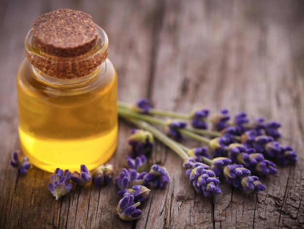 Lavender oil with flower on wooden surface