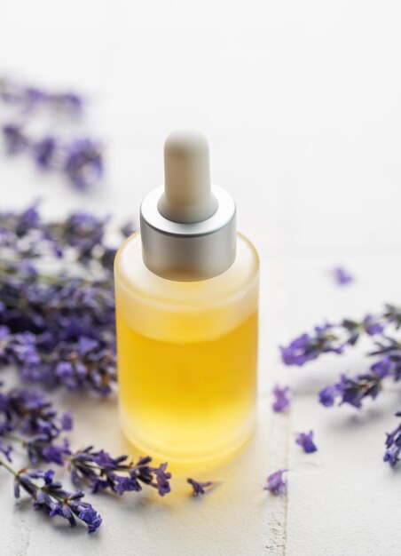 Lavender spa Lavender natural essential oil and fresh lavender on a white tile background